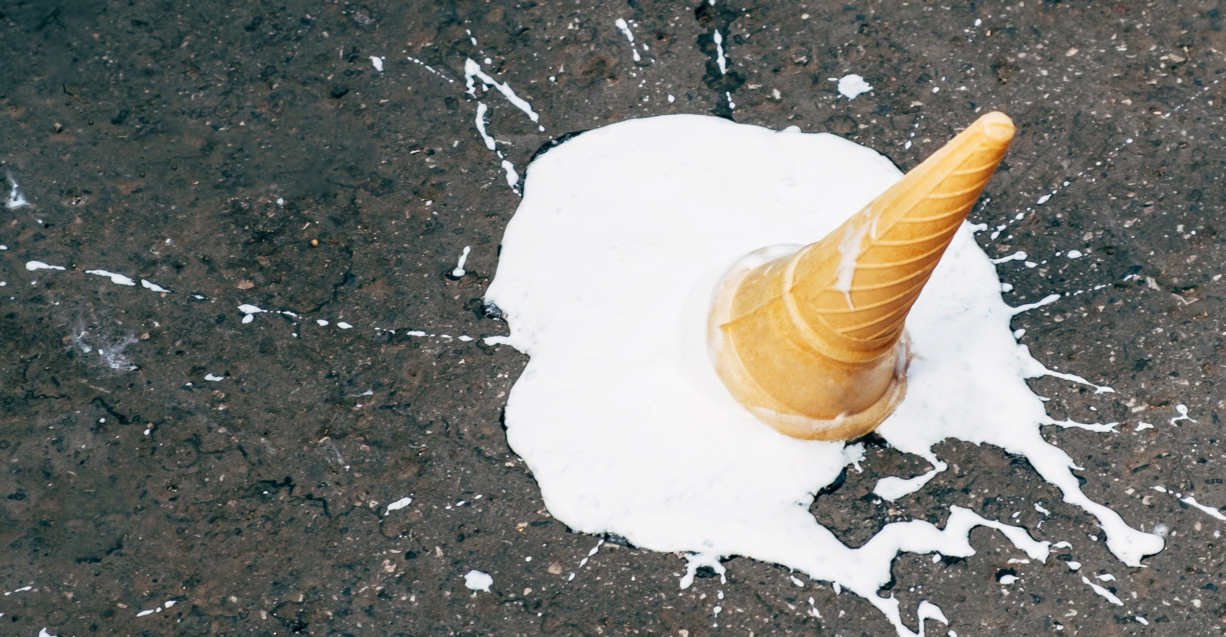 Fallen ice cream cone on asphalt